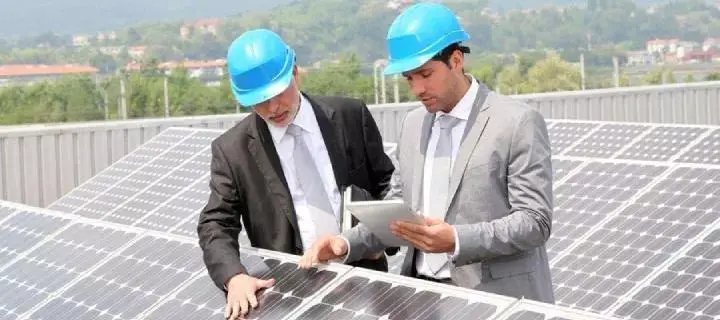 Dwóch facetów w kaskach sprawdzających panele słoneczne